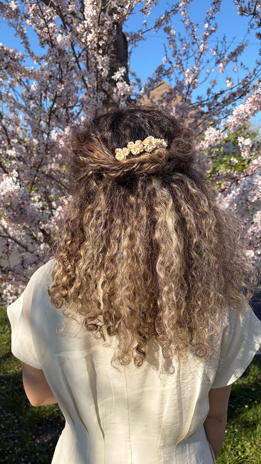 Beatrice hair comb worn in a twisted half-up style beneath a cherry blossom tree