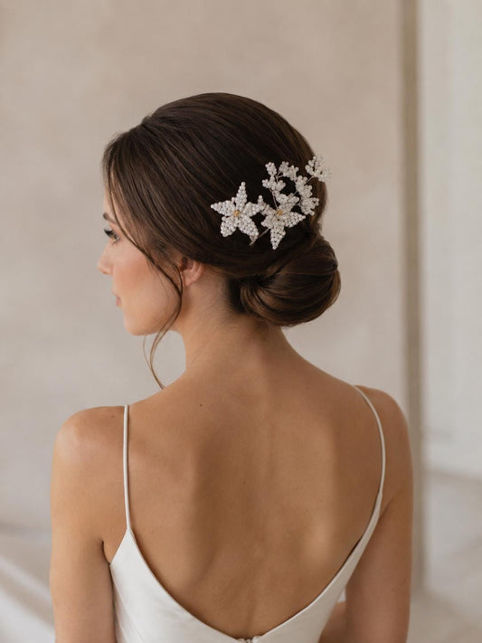 Edith hair vine curved along a low bridal chignon with an ivory satin gown